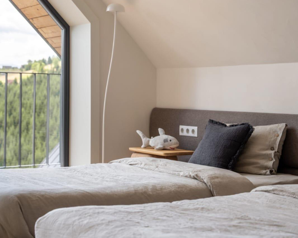 Quiet bedroom with twin beds and natural light, demonstrating the excellent soundproofing performance of eco panels made from straw and reeds.