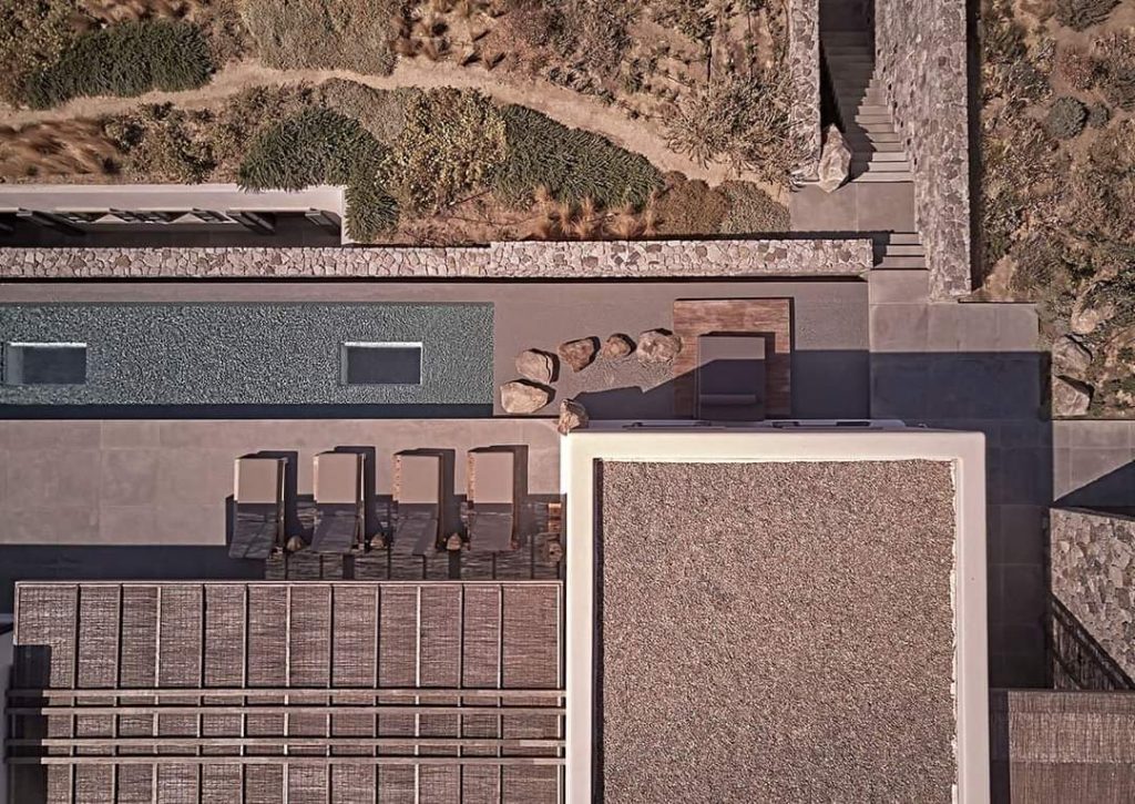 Aerial view of a modern eco-friendly home with natural landscaping and solid design, illustrating resistance to environmental stressors like wind and earthquakes