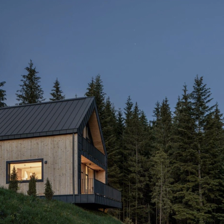 Modern straw panel house in the forest, showcasing durability and 120+ year lifespan of eco-friendly construction materials